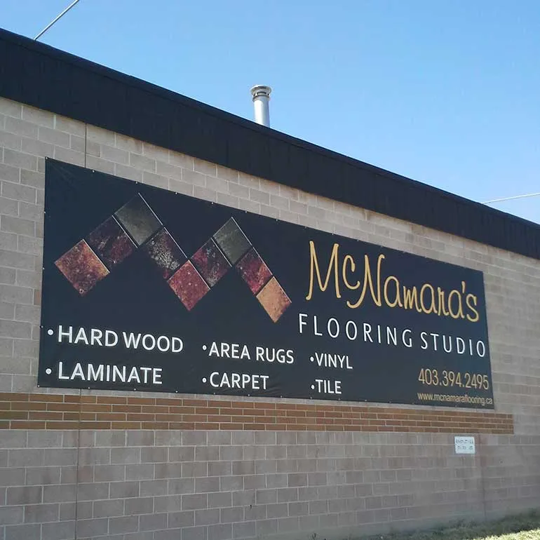 Large printed banner mounted on a brick wall